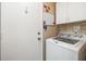 Convenient laundry area features a modern washing machine and door to the outside at 2411 New Haven Cir # 70, Sun City Center, FL 33573