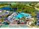 A beautiful aerial view of the community pool, surrounded by palm trees, with a view of the golf course and a lake in the background at 2411 New Haven Cir # 70, Sun City Center, FL 33573