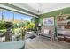 Cozy sunroom featuring green walls and a charming view of the landscaped backyard at 2411 New Haven Cir # 70, Sun City Center, FL 33573
