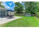 Spacious backyard with a patio under a blue umbrella and colorful pool perfect for outdoor activities at 2512 Jamaica St, Sarasota, FL 34231