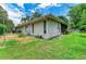 Exterior view of home, with screened lanai, well-maintained landscaping, and gravel ground cover on the side of the house at 2512 Jamaica St, Sarasota, FL 34231