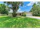 Charming one-story home with lush front lawn and mature trees offering curb appeal and shade at 2512 Jamaica St, Sarasota, FL 34231
