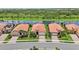 Aerial view of single-story homes along the water with tile roofs, landscaping, and two-car garages at 25143 Spartina Dr, Venice, FL 34293