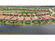 Waterfront homes with screened-in pools sit along a tranquil lake in this community aerial view at 25143 Spartina Dr, Venice, FL 34293