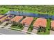Aerial view of single-story homes along the water, tile roofs, screened in pools and well-maintained landscaping at 25143 Spartina Dr, Venice, FL 34293