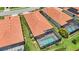 Aerial view of the tile roof and the screened in pool with views of the neighbors tile roofs and the landscaping at 25143 Spartina Dr, Venice, FL 34293