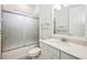 This bathroom offers a frosted glass shower door, white cabinets, and a marble countertop at 25143 Spartina Dr, Venice, FL 34293
