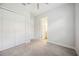 This bedroom has neutral colored walls, carpet, a ceiling fan, closet and leads to the bathroom at 25143 Spartina Dr, Venice, FL 34293