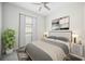 This bedroom has neutral walls with a queen bed, ceiling fan, and two lamps on the nightstands at 25143 Spartina Dr, Venice, FL 34293