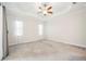 Spacious bedroom offers neutral walls, carpeted floor, ceiling fan, and bright natural light at 25143 Spartina Dr, Venice, FL 34293
