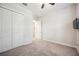 This bedroom has neutral colored walls, carpet, a ceiling fan and a closet at 25143 Spartina Dr, Venice, FL 34293