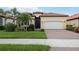 Charming home featuring a barrel tile roof, manicured lawn, and a two-car garage at 25143 Spartina Dr, Venice, FL 34293