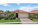 Charming single-story home with a well-manicured lawn and landscaping, a two-car garage, and a tile roof at 25143 Spartina Dr, Venice, FL 34293