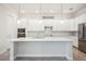 Bright kitchen with white cabinetry, stone countertops, and stainless steel appliances at 25143 Spartina Dr, Venice, FL 34293