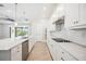 Modern kitchen with white cabinets, stainless steel appliances, and peninsula seating at 25143 Spartina Dr, Venice, FL 34293