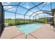 View of the pool, jacuzzi and the surrounding landscaping inside of a screened enclosure overlooking the golf course at 25143 Spartina Dr, Venice, FL 34293
