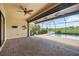 Screened-in pool patio with brick pavers, ceiling fan, palm tree wall decor, and a view of the golf course and pool at 25143 Spartina Dr, Venice, FL 34293