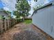 Fenced backyard with overgrown grass and adjacent to gray house at 27 Tucker Ave, Sarasota, FL 34232