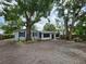 Charming single-story home with a screened-in porch and beautiful mature trees in the front yard at 27 Tucker Ave, Sarasota, FL 34232