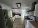 Functional kitchen features white cabinetry, stainless steel refrigerator, and tile flooring at 27 Tucker Ave, Sarasota, FL 34232