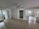 Open-concept living room with tile flooring, neutral walls, standard ceiling fan, and access to additional living space at 27 Tucker Ave, Sarasota, FL 34232