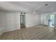 Spacious living room with neutral paint, ceiling fan, tile flooring, and access to the kitchen at 27 Tucker Ave, Sarasota, FL 34232