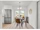 A dining area adjacent to the kitchen with stainless steel refrigerator and modern light fixture at 2802 21St W St, Bradenton, FL 34205