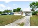 Exterior of home with well-manicured front lawn, wood shutters and a carport at 2802 21St W St, Bradenton, FL 34205