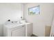 White laundry room with washer, dryer, and a window to the outside at 2802 21St W St, Bradenton, FL 34205