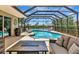 A screened-in pool area offers comfortable seating and relaxing lake views at 2875 Grazeland Dr, Sarasota, FL 34240