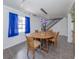 Bright dining area featuring modern lighting, wooden table and chairs, complemented by vivid blue curtains at 305 Chauncey Ave, Bradenton, FL 34208