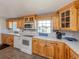 Bright kitchen features charming wood cabinets, white appliances, and backsplash detailing at 305 Chauncey Ave, Bradenton, FL 34208