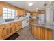 Inviting kitchen features wood cabinetry, a breakfast bar, and modern white appliances at 305 Chauncey Ave, Bradenton, FL 34208