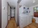 Practical laundry room with washer, dryer, storage shelves, and wood flooring at 305 Chauncey Ave, Bradenton, FL 34208