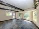Bright living room featuring exposed beams, tiled floors, natural light, and views of the outdoors at 305 Chauncey Ave, Bradenton, FL 34208