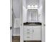 Bathroom vanity with white cabinets, black countertop, and modern lighting at 3379 Chestertown Loop, Bradenton, FL 34211