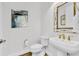 Modern bathroom with white toilet, sink, gold hardware, and decorative mirror at 3379 Chestertown Loop, Bradenton, FL 34211