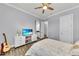 Bright bedroom featuring light colored bedspread, guitar, and TV at 3379 Chestertown Loop, Bradenton, FL 34211
