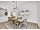 Well-lit dining room with modern light fixture and outdoor views through shuttered windows at 3379 Chestertown Loop, Bradenton, FL 34211
