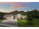 Charming single-story home featuring a tile roof, paver driveway, three-car garage, and meticulously landscaped front yard at 3379 Chestertown Loop, Bradenton, FL 34211