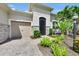 Beautiful home featuring a two-car garage, front door, and lush tropical landscaping at 3379 Chestertown Loop, Bradenton, FL 34211