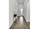 Bright hallway featuring wood-look tile flooring, neutral paint, and decorative flower arrangement at 3379 Chestertown Loop, Bradenton, FL 34211