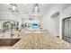 Modern kitchen featuring granite countertops, stainless steel appliances, and a view of the living area at 3379 Chestertown Loop, Bradenton, FL 34211