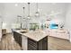 Open-concept kitchen with a large center island, stainless steel appliances, and a view of the living room at 3379 Chestertown Loop, Bradenton, FL 34211