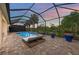 Inviting pool area with a lounge chair, lush plants, surrounded by a screened-in enclosure at 3379 Chestertown Loop, Bradenton, FL 34211