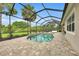Beautiful screened-in pool with brick pavers and blue decorative tile with a view to a lush, green backyard at 3379 Chestertown Loop, Bradenton, FL 34211