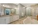 Well-lit bathroom featuring a soaking tub, glass enclosed shower, granite counters, and double sinks at 3430 77Th W St # 301, Bradenton, FL 34209