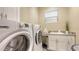 Functional laundry room with modern washer, dryer, sink, and storage at 3430 77Th W St # 301, Bradenton, FL 34209