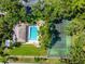 A bird's eye view of Wilkinson Woods' tennis court and community pool nestled within its mature trees and lush landscaping at 3530 Wilkinson Woods Dr # 14, Sarasota, FL 34231