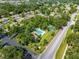 Aerial shot of a neighborhood highlighting the community pool and tennis courts surrounded by lush greenery at 3530 Wilkinson Woods Dr # 14, Sarasota, FL 34231